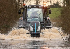 Geoffrey Boyd driving a Valtra tractor through the deep floods near Lisnaskea